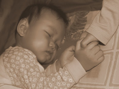 Zaria and Zara holding hands when they slept