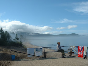 Am Anleger: Tanja genießt die Morgenstimmung während der Wache und hält gleichzeitig Ausschau nach einem Boot, welches uns zurück zur Ajaja-Bucht bringen könnte. Im Hintergrund Erkennt man Nebelschwaden und tiefziehende Wolkenreste.