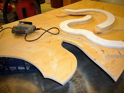 Jigsawing an acoustic bass guitar mold from a sheet of plywood.