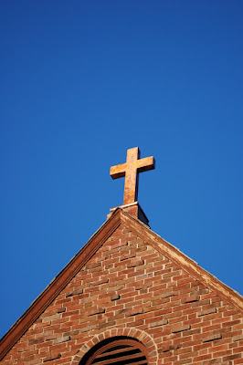 Copper cross shining against dark blue sky. St. Mary's Parish, Boise ID.