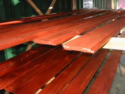 Redwood stained siding against green metal